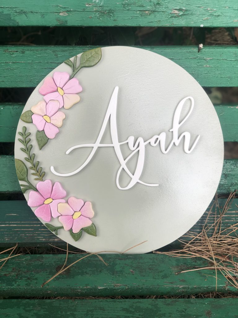 wooden name sign in grey and pink colour scheme with flowers
